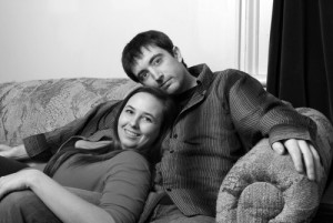 A happy young couple enjoy some cuddling on the couch.